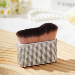 Gros plan d'un pinceau à maquillage de luxe avec strass et poils doux sur socle en bois