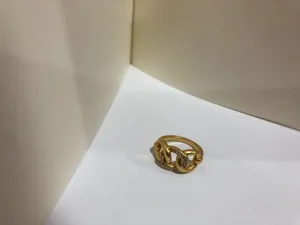 Dettaglio di un anello a nodo dorato con brillanti inserti in strass