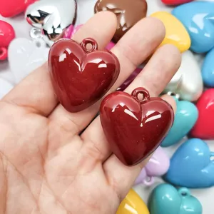 Detailed view of glossy dark red acrylic heart charms for DIY jewelry making and crafts