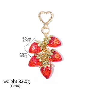 Detailed size and weight view of a translucent red strawberry keychain charm