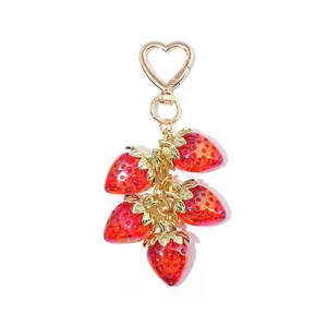 Close-up of a sweet translucent red strawberry keychain with a heart-shaped clasp