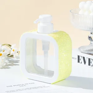 Close-up detail of yellow rhinestone encrusted square refillable pump dispenser bottle