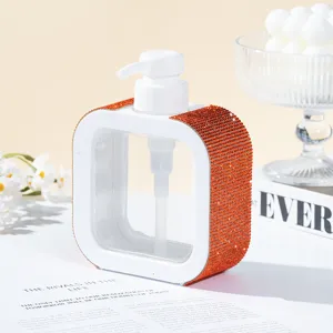 Detail view of a square refillable pump bottle decorated with orange rhinestones.