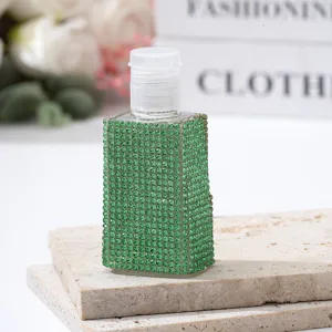 Detail showing sparkling green rhinestone decoration on travel perfume dispensing bottle