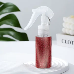Nahaufnahme der funkelnden roten Strass-Struktur einer fein zerstäubenden Sprühflasche