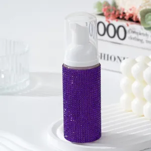 Vue détaillée de la bouteille distributrice de mousse de voyage en strass violets.