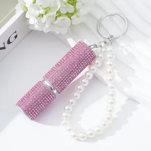 Detailed view of pink rhinestone 5ml perfume atomizer with pearl bead keychain strap.