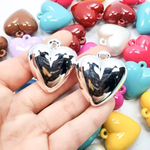Close-up of colorful acrylic heart charms with metallic silver finish for DIY jewelry and keychains