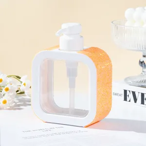 Detail view of white refillable pump bottle with vibrant orange rhinestone embellishments