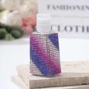 Close-up of the colorful gradient rhinestone detailing on a luxury travel spray bottle.