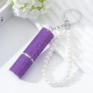 Detail view of purple rhinestone perfume atomizer bottle with pearl keychain strap