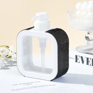 Macro view of a square white pump bottle with black rhinestone side decorations