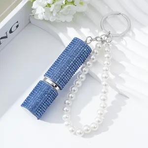 Elegant detail of blue rhinestone 5ml perfume atomizer keychain with a white pearl strap