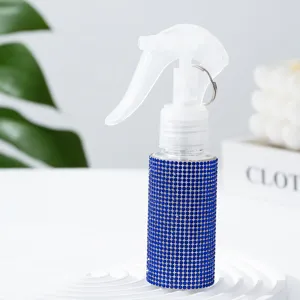 Nahaufnahme einer mit blauen Strasssteinen verzierten PET-Sprühflasche