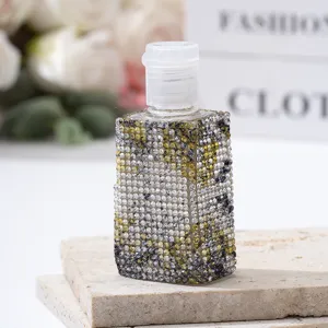 Detailed macro view of luxury rhinestone covered perfume spray bottle on stone