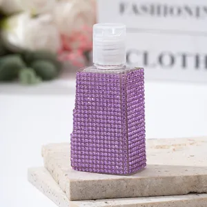 Macro view of a luxury travel perfume spray bottle covered in sparkly purple rhinestones