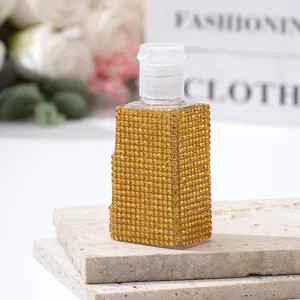 Detailed macro view of a luxury gold rhinestone-encrusted spray bottle for travel perfumes