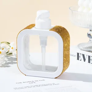 Close-up of elegant white soap dispenser with luxury gold rhinestone embellishments