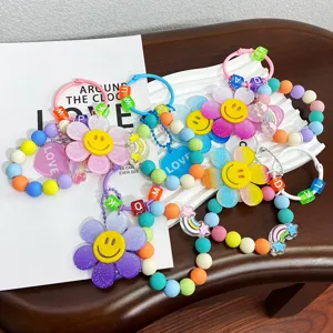 Nahaufnahme bunter Perlen-Sonnenblumen-Schlüsselanhänger mit Smiley- und Regenbogen-Anhängern.