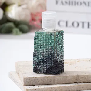 Detailed macro shot of a luxury rhinestone-studded gradient spray bottle on stone slabs.