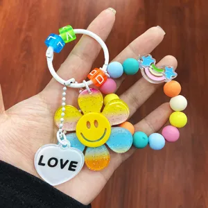 Detailansicht eines bunten Sonnenblumen-Schlüsselanhängers mit Smiley und Perlenband