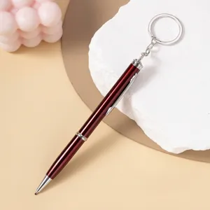 Sleek burgundy ballpoint pen with integrated silver keychain ring shown on prop