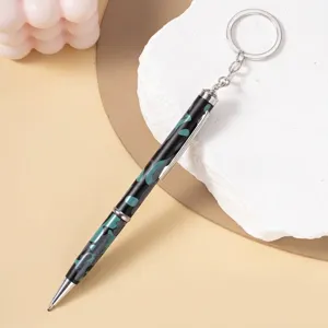 Close-up detail of camouflage ballpoint pen with integrated metal keychain ring
