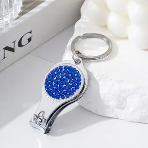 Detail of nail clipper bottle opener keychain with blue rhinestones