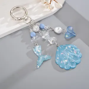 Vue détaillée du porte-clés thème océan avec coquillage bleu et queue de sirène.