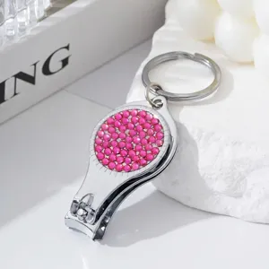 Close-up of pink rhinestone 2-in-1 nail clipper and bottle opener keychain tool