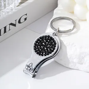 Close-up of a silver multifuntional nail clipper keychain with black rhinestone inlay