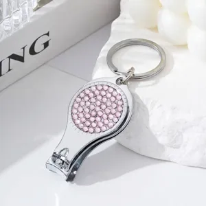 Silver nail clipper keychain with pink rhinestone detail and bottle opener function