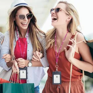 Happy women wearing sparkling rhinestone lanyards with ID badge holders and keychains.