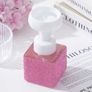Detailed view of pink rhinestone soap dispenser with elegant white flower foam pump.