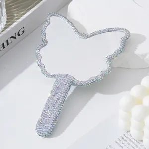Primo piano di uno specchio a mano a forma di farfalla decorato con strass lucenti.