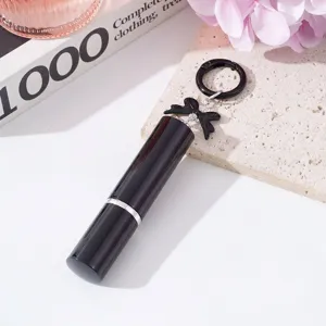 Primer plano de un frasco pulverizador de perfume negro de 5ml con un lazo decorativo.
