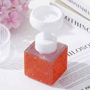 Detail shot of elegant orange rhinestone soap dispenser with white flower-shaped pump