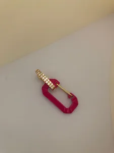 Close-up of trendy pink enamel carabiner earring with sparkling white stones