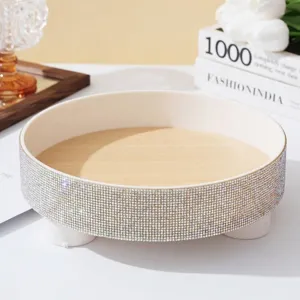 Close-up view of luxury round tray with sparkling rhinestone rim and wood texture base.