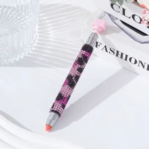 Close-up detail of luxury leopard pattern rhinestone nail dotting pen on fashion book backdrop