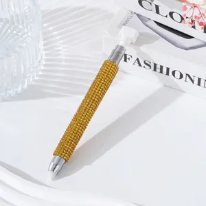 Macro detail of the double-ended nail art dotting pen featuring a yellow rhinestone body