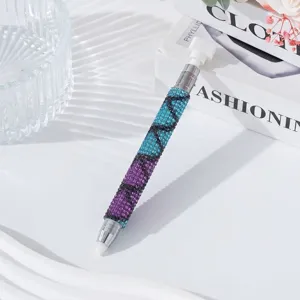 Macro detail of dual-ended nail art dotting pen decorated with purple and blue rhinestones