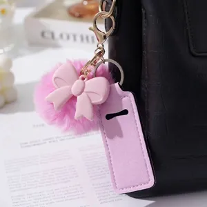 Detail view of pink bow and pompom keychain with lavender lipstick holder sleeve