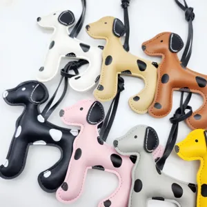 Dettaglio ravvicinato di vari ciondoli colorati per borse in pelle a forma di dalmata