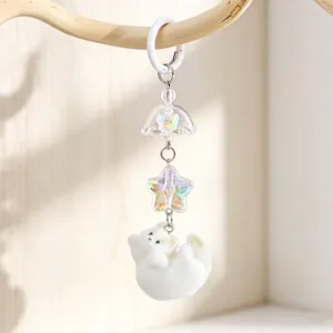Detailed view of a cute white flocked kitten keychain featuring an iridescent star pendant.