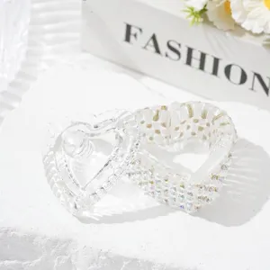 Close-up of heart-shaped crystal glass nail art jar with pearls and rhinestones