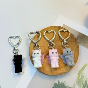 Detail view of plush cat keychains with heart metal ring in four assorted colors.