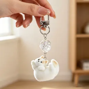 Close-up of cute white flocked cat keychain with crystal bead detail