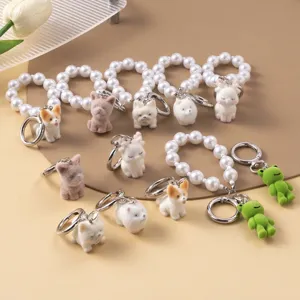 Detailed view of various flocked animal charms with elegant pearl bead wristlet straps.