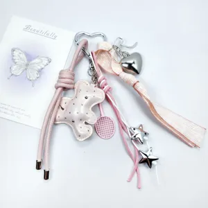 Close-up detail of sweet pink leather bear and metallic star charms on a DIY keychain